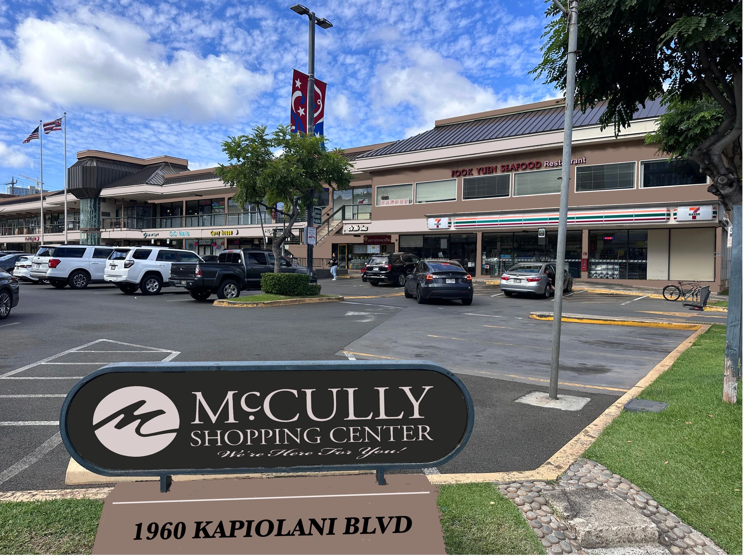 McCully1 Sign for McCully Shopping Center at 1960 Kapiolani Blvd with parking lot, cars, and storefronts in the background.