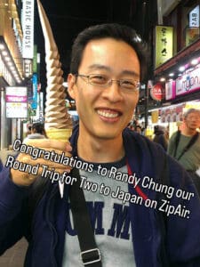 A man with glasses smiles and holds a tall soft-serve ice cream cone on a busy city street at night. Text congratulates Randy Chung for winning a round trip to Japan for two on ZipAir.